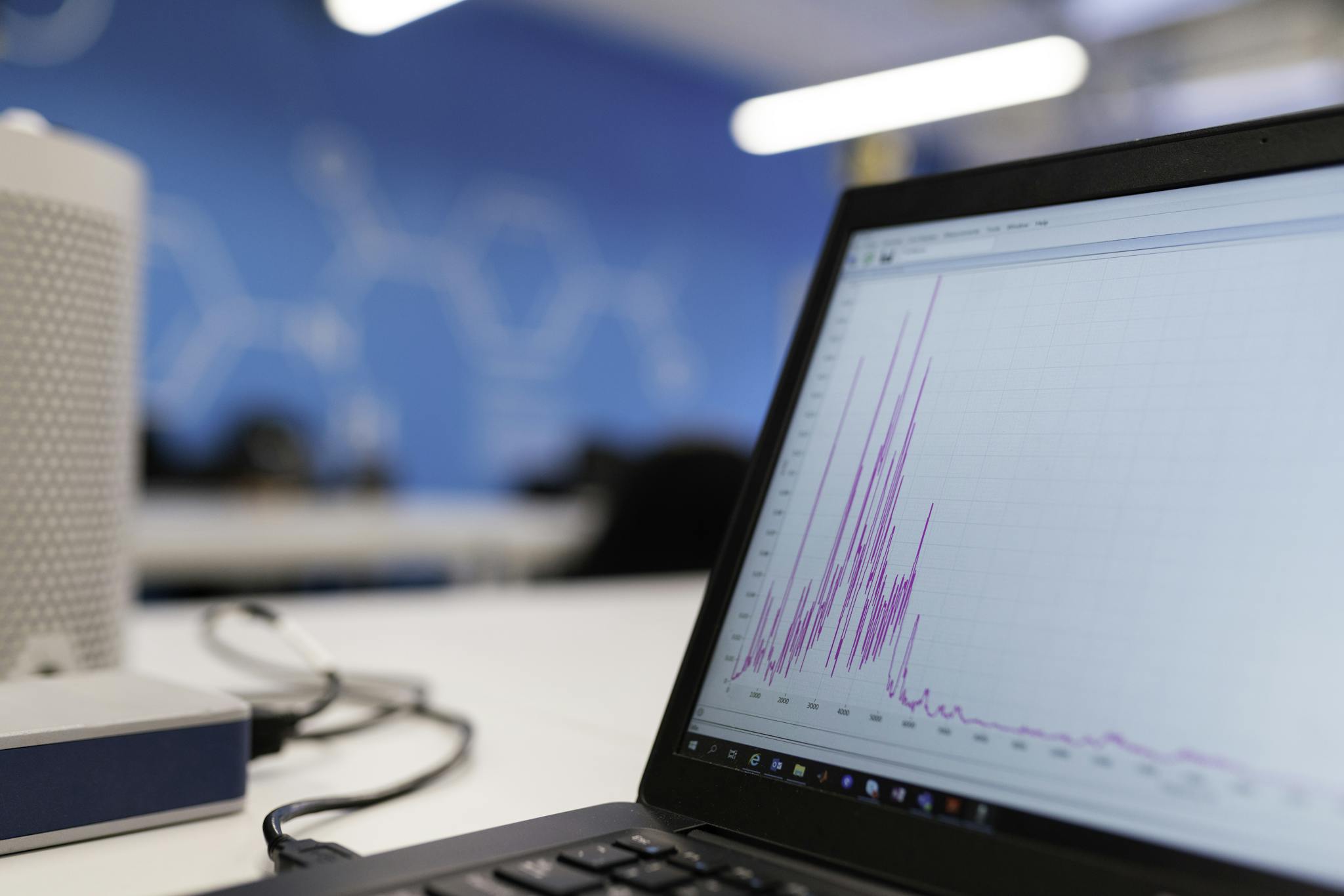 Laptop displaying data analytics graph in a modern office setting, symbolizing growth and technology.